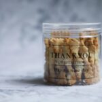A clear container filled with cookies, featuring a thank you message. Perfect gift idea.