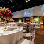 Stunning wedding reception setup with elegant floral centerpieces and ambient lighting.