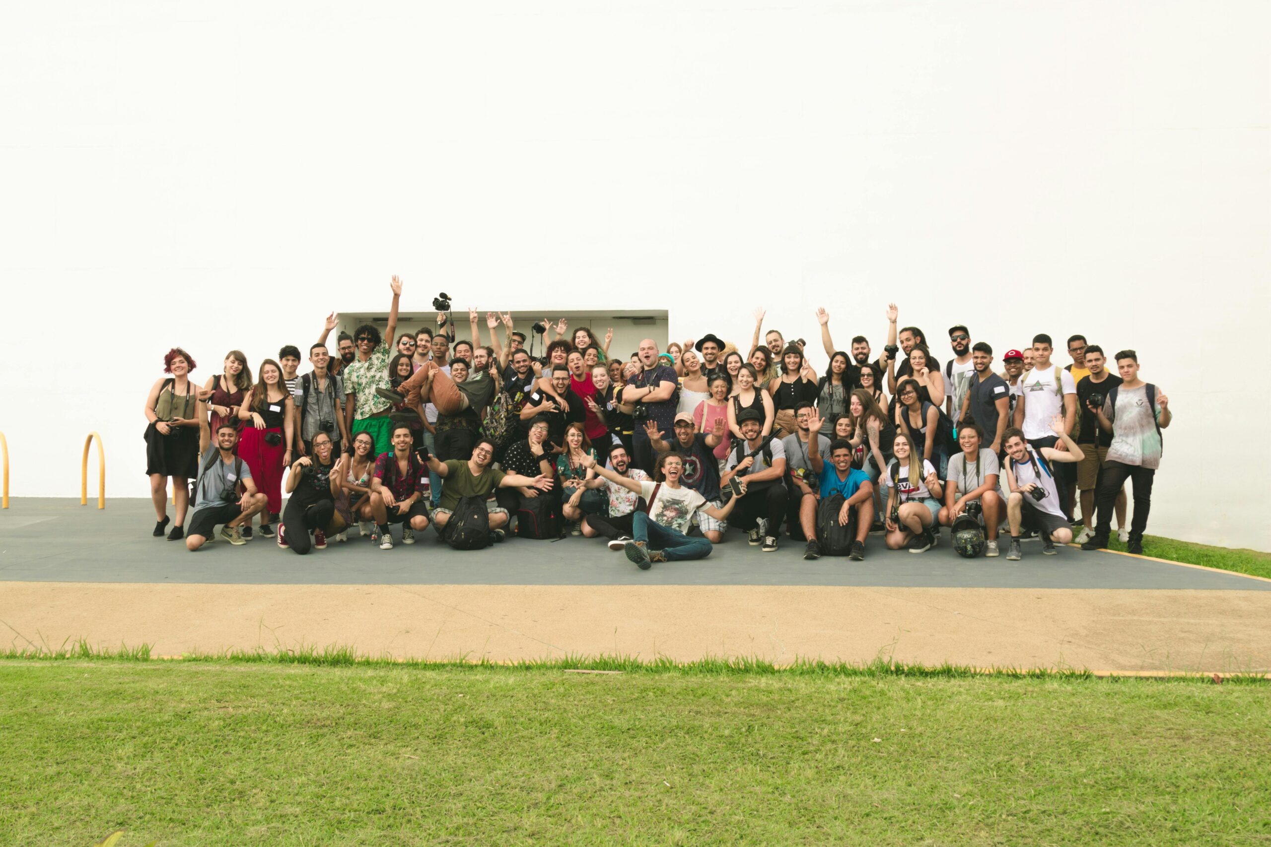 A joyful group of diverse friends celebrating outdoors on a sunny day.