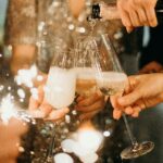 People toasting with champagne glasses amidst sparklers at a festive party.